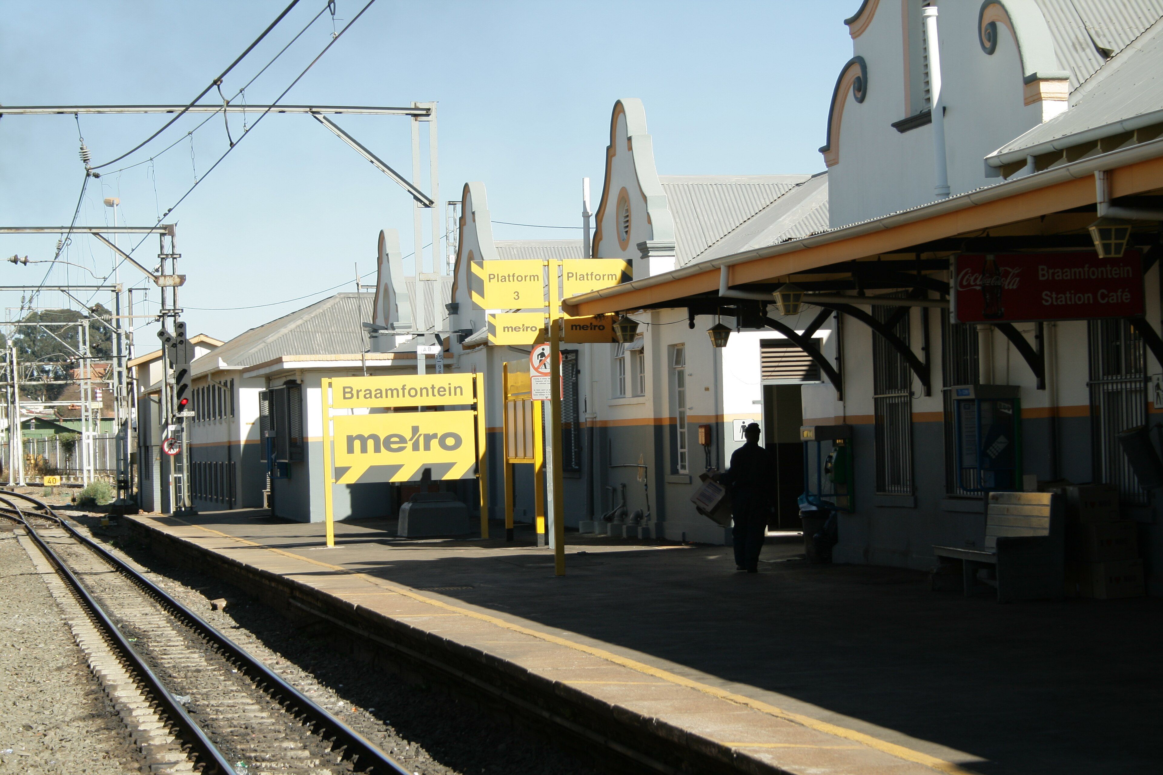 The platform and Cape Dutch-gabled station buildings at Braamfontein railway station, Johannesburg, on a clear day
